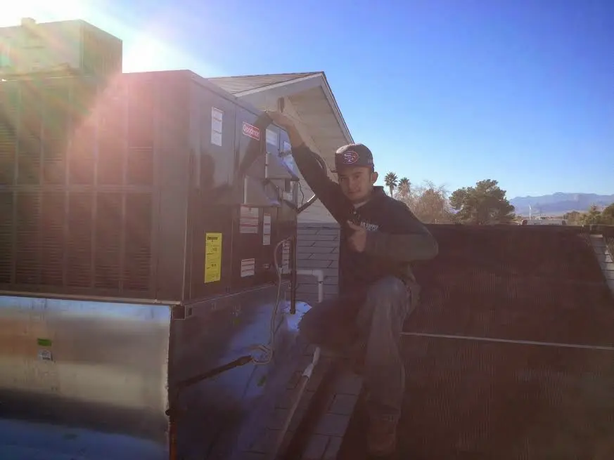 HVAC technician performing HVAC Inspection on a rooftop unit in Merrimack